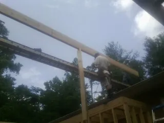 Carpenter setting a ridge beam over a new addition frame — Ice Dam Removal by Roofing Brothers in Willimantic