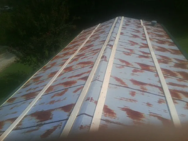 Rusted metal roof panels with new wood purlins before replacement — Storm Damage Roof Repair in Willimantic by Roofing Brothers