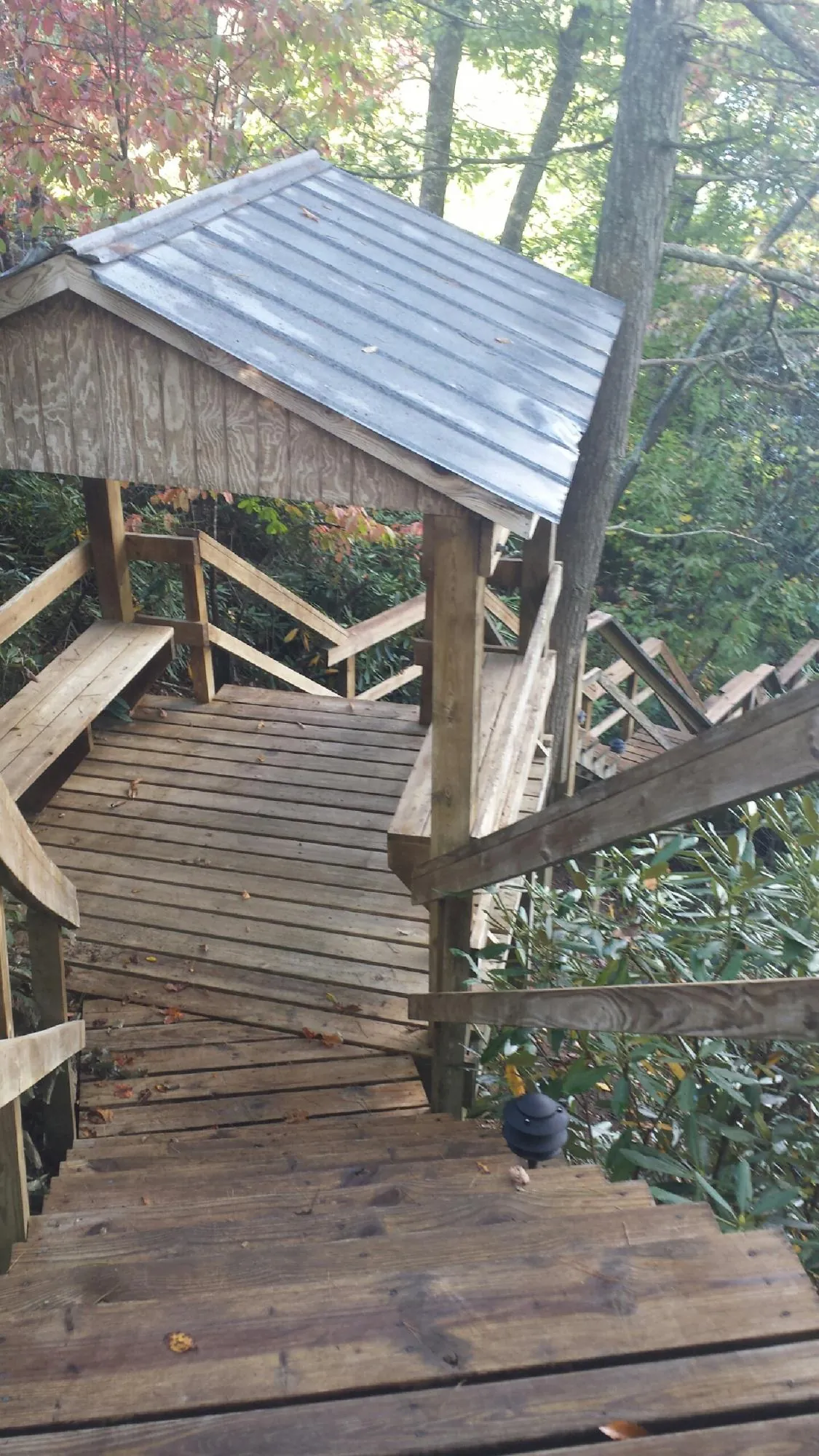 Metal roofed shelter over wooden steps on a wooded walkway — Skylight Repair & Installation work by our crew in Willimantic