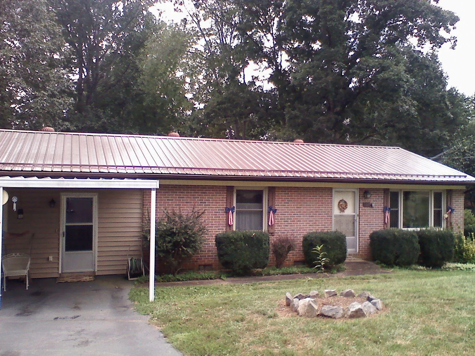 Bronze metal roof and carport on a brick ranch home — Roof Repair work by our crew in Willimantic